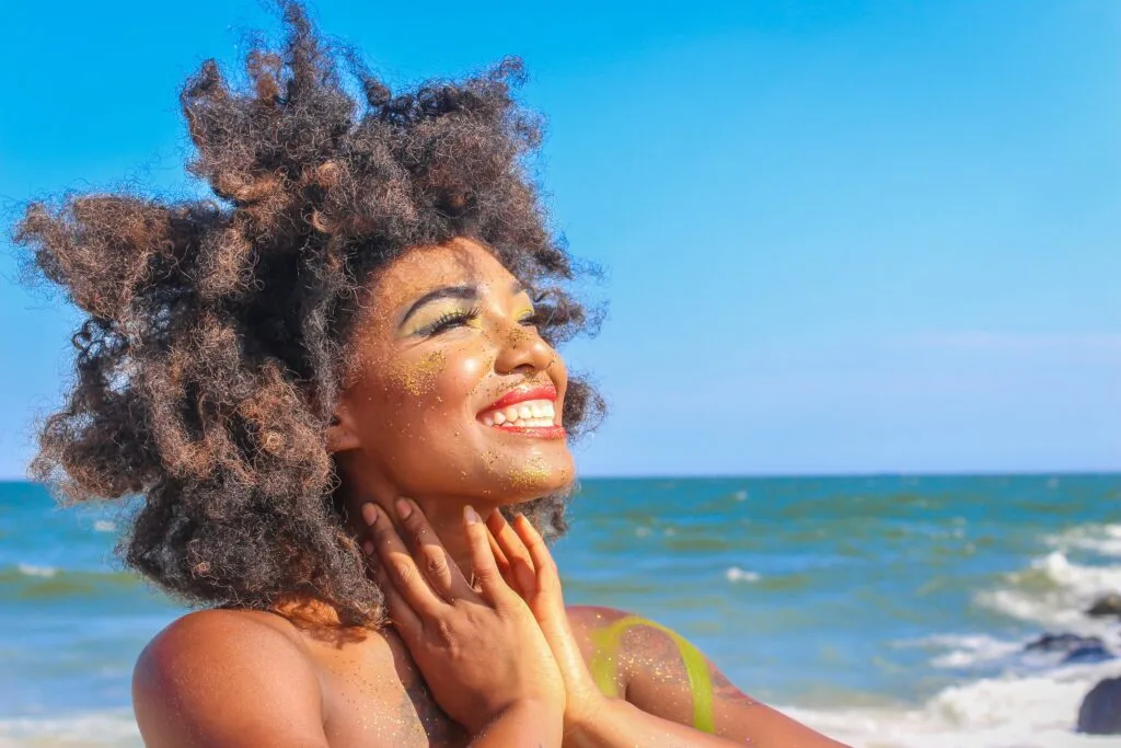 A woman smiling in the sun. She can escape productivity hell.